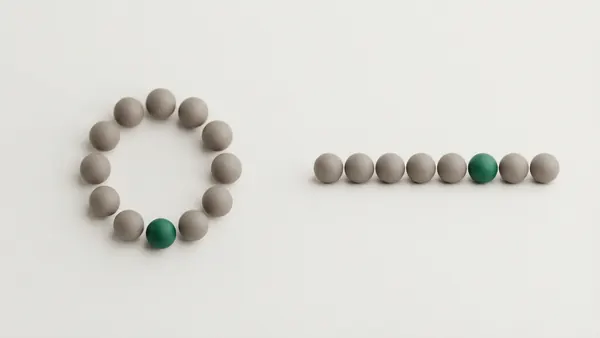 A ring of grey clay spheres beside a straight row of spheres, one sphere in each group green