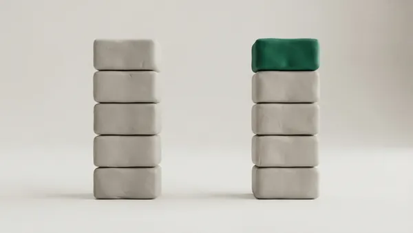 Two identical columns of grey clay blocks, the right one with an extra green block on top