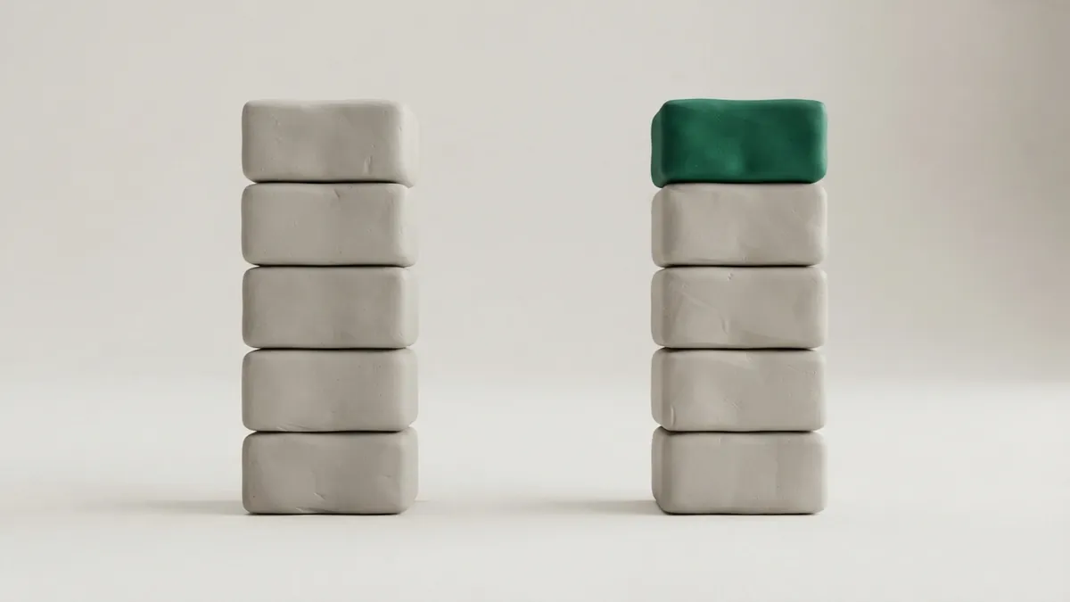 Two identical columns of grey clay blocks, the right one with an extra green block on top